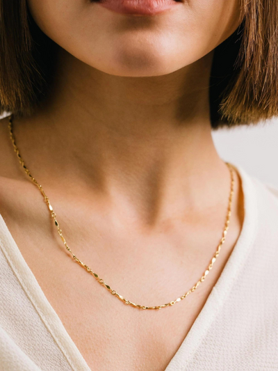 MODEL WEARING GOLD CHAIIN NECKLACE