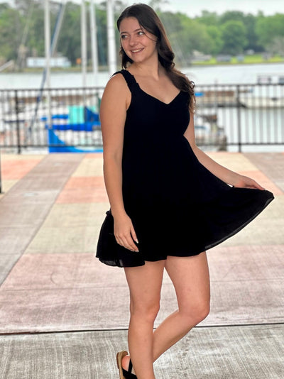 Megan in black dress looking to the side