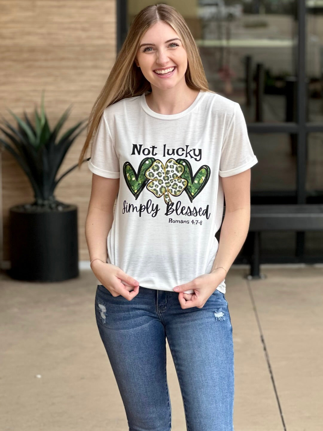 Lexi in simply blessed graphic tee smiling holding top