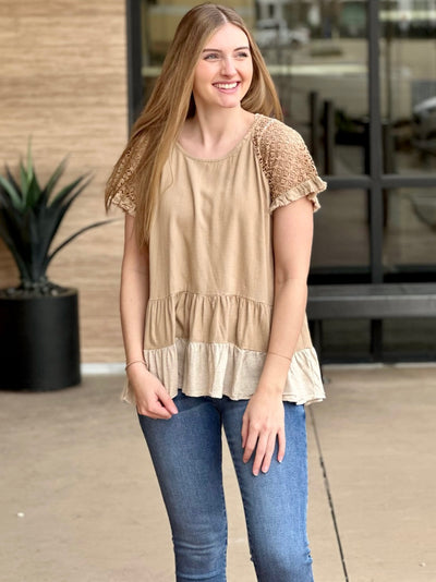 Megan in taupe top looking to the side smiling