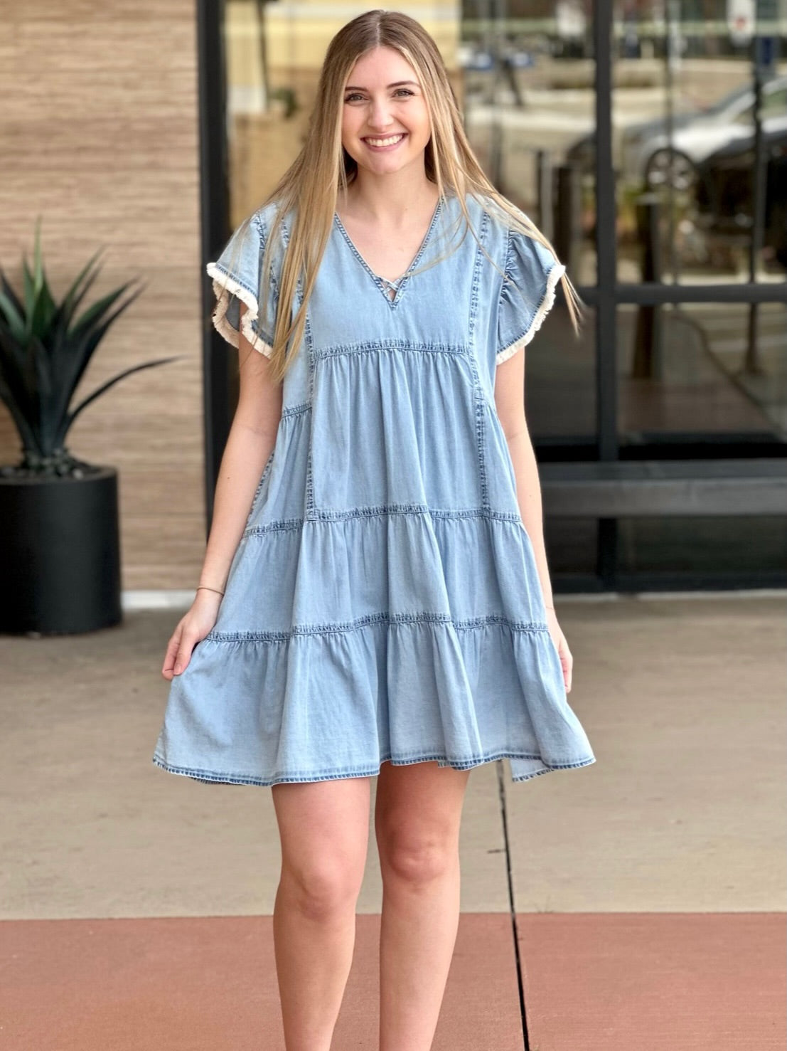 Lexi in denim blue dress holding dress