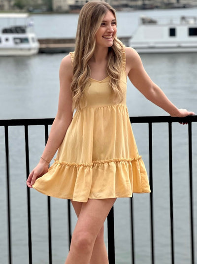 Lexi in yellow dress front view holding dress 