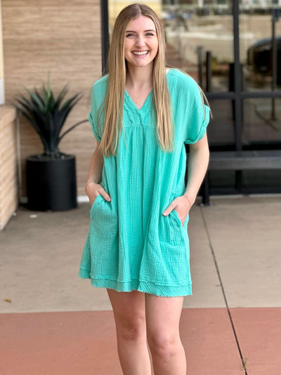 Lexi in mint dress front view both hands in pockets smiling
