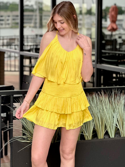 Lexi in yellow romper hand out looking down