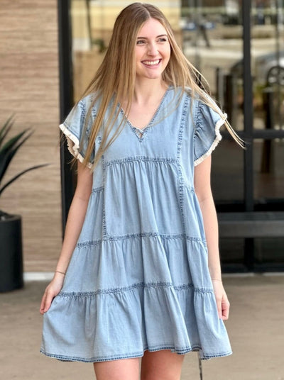 Lexi in denim blue dress front view holding dress