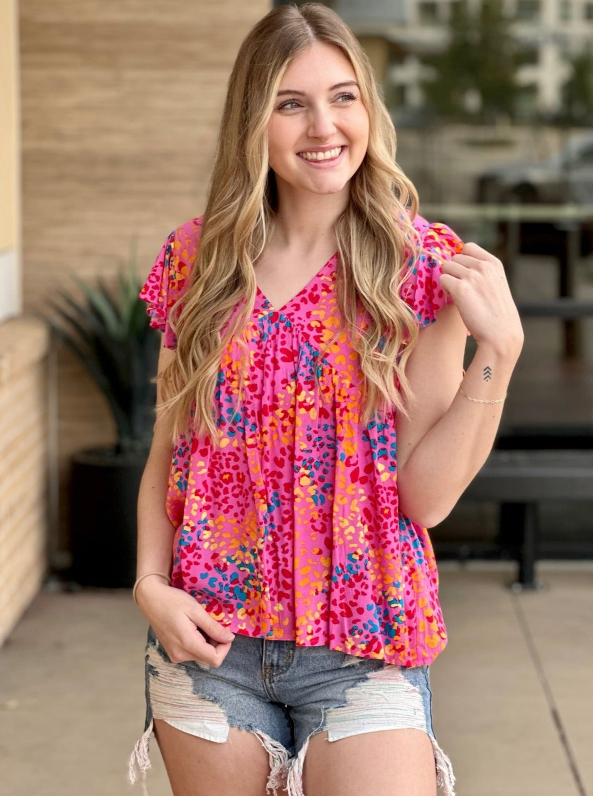 Lexi in hot pink blouse front view looking to the side 