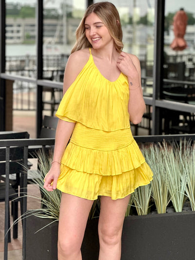 Lexi in yellow romper smiling to the side