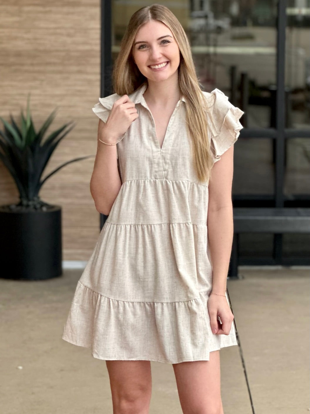 Lexi in oatmeal dress holding dress
