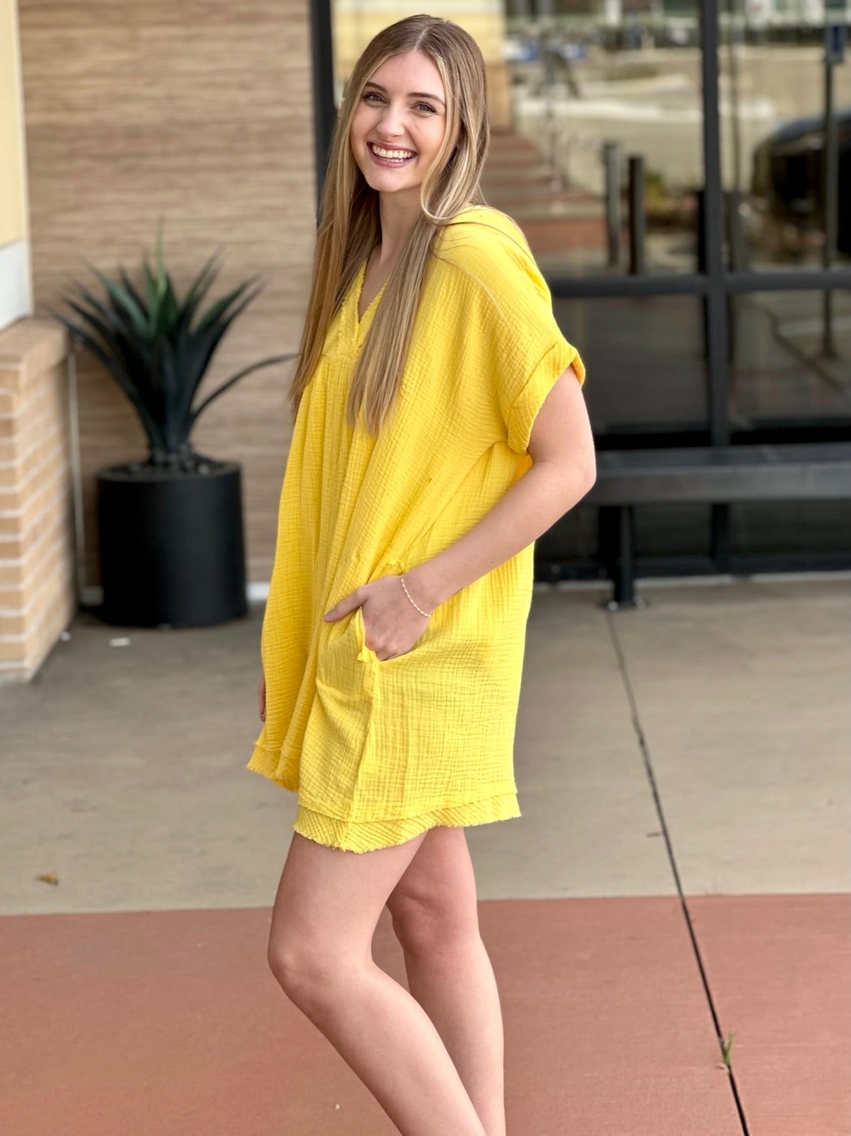 Lexi in yellow dress side view hand in pocket