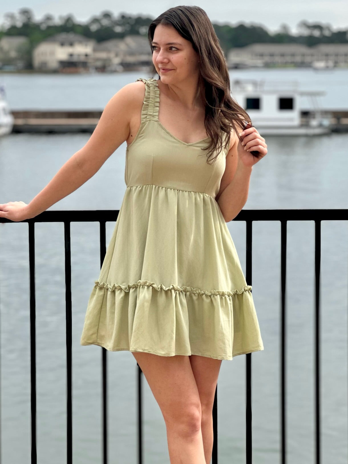 Megan in olive dress looking to the side