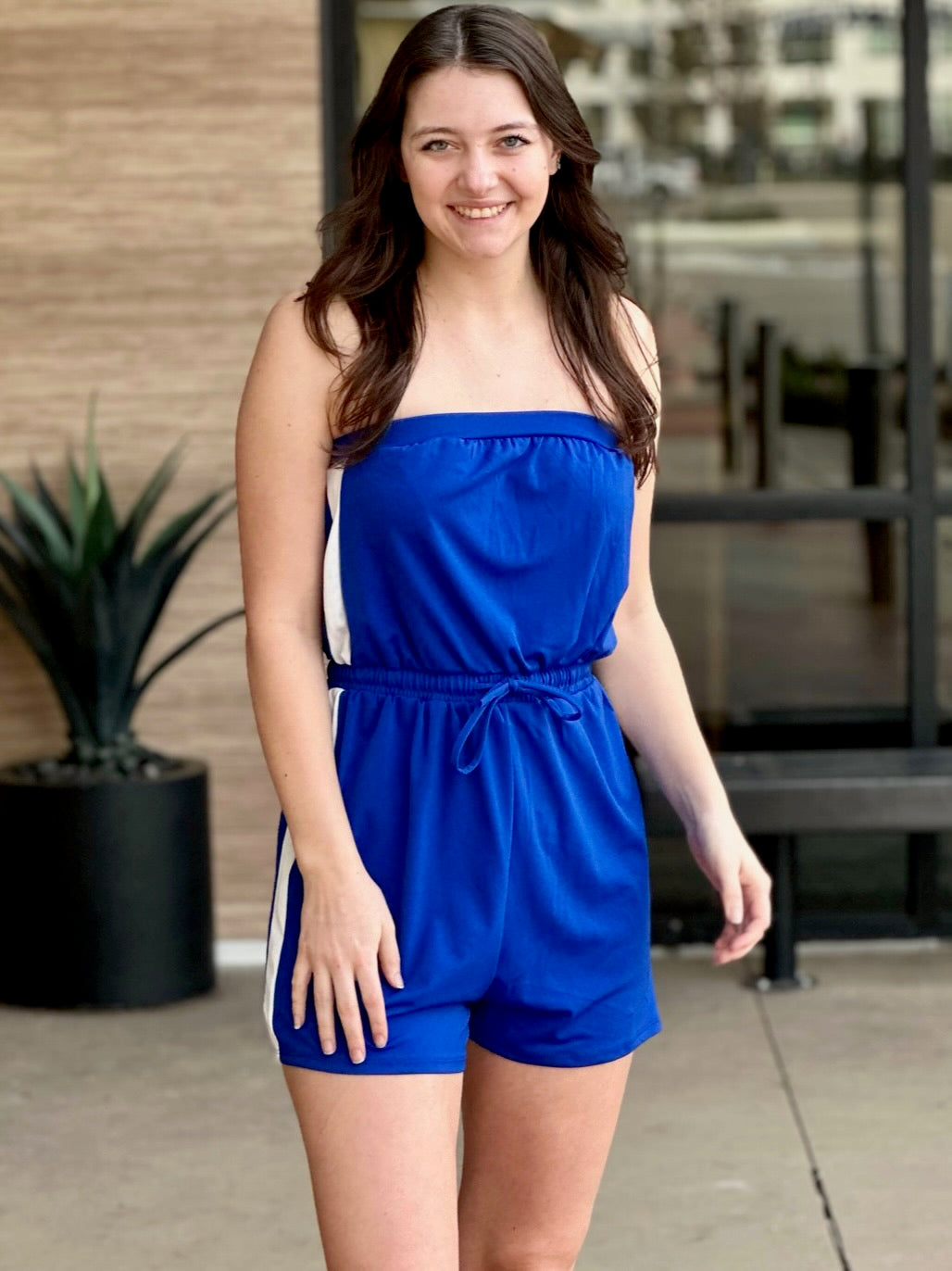 Megan in royal blue jumpsuit front view hand on thigh