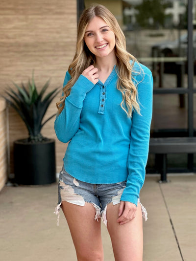 Lexi in turquoise henley holding top