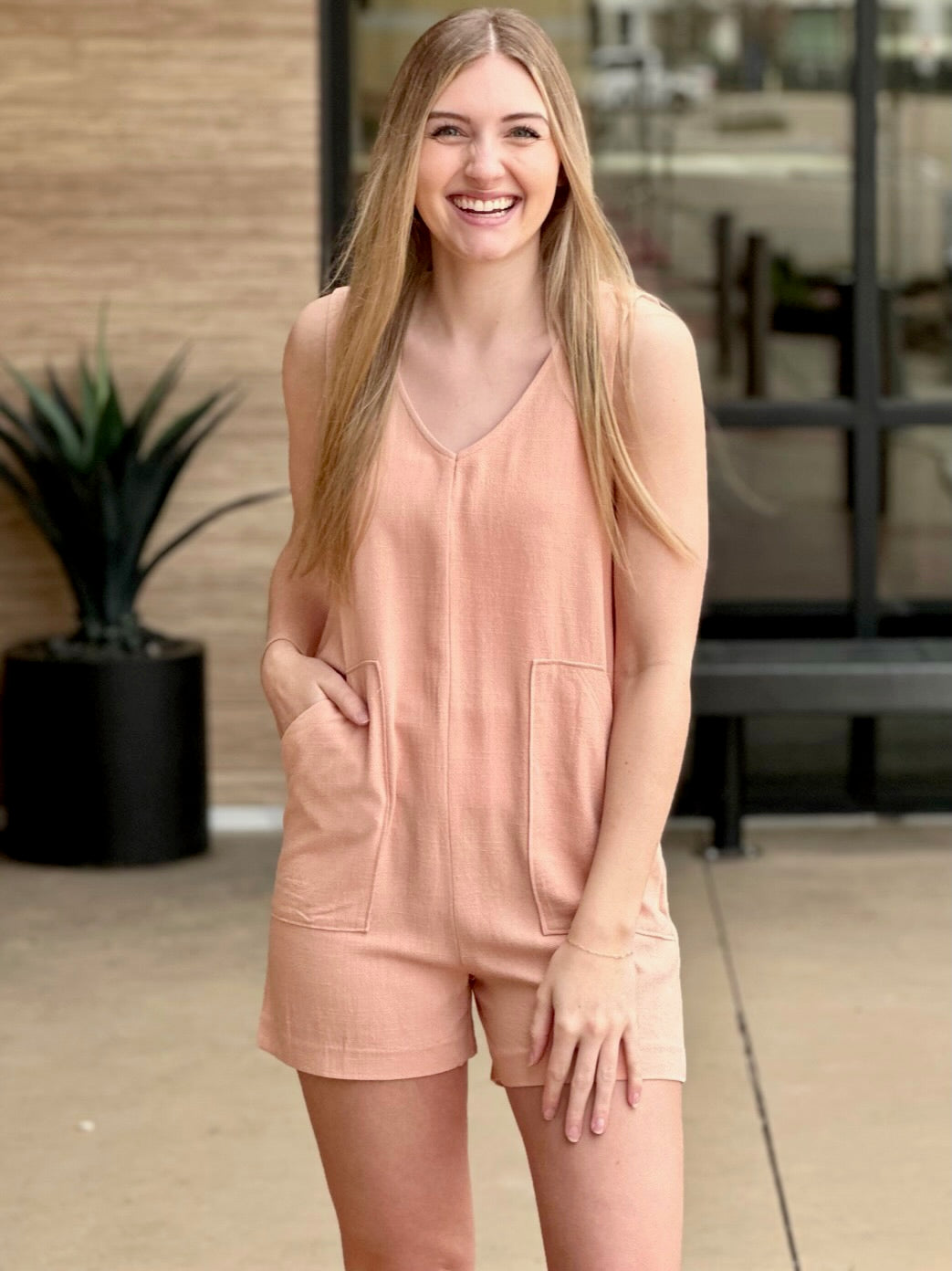 Lexi in tropical peach romper front view smiling