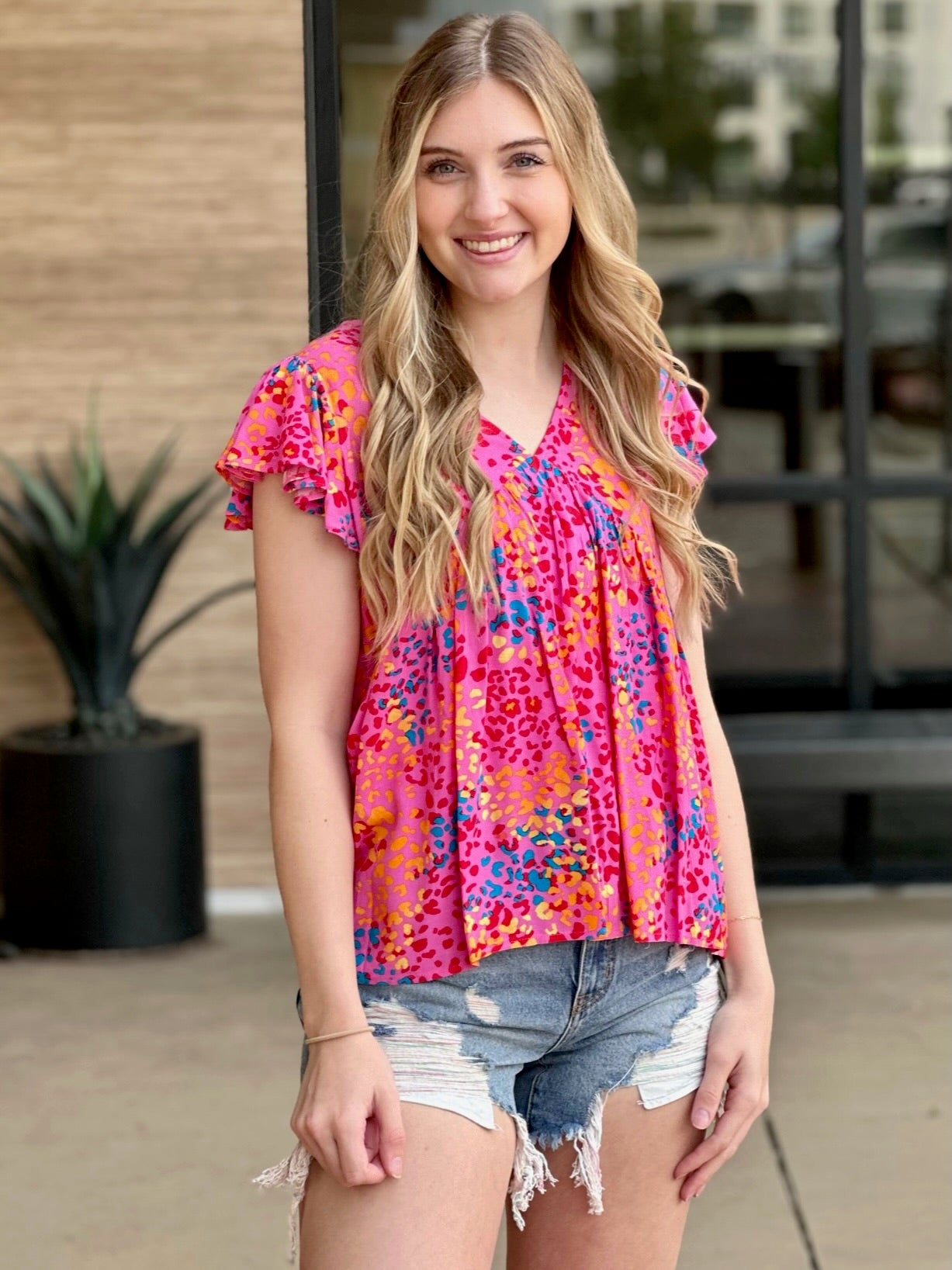 Lexi in hot pink blouse front view hands down