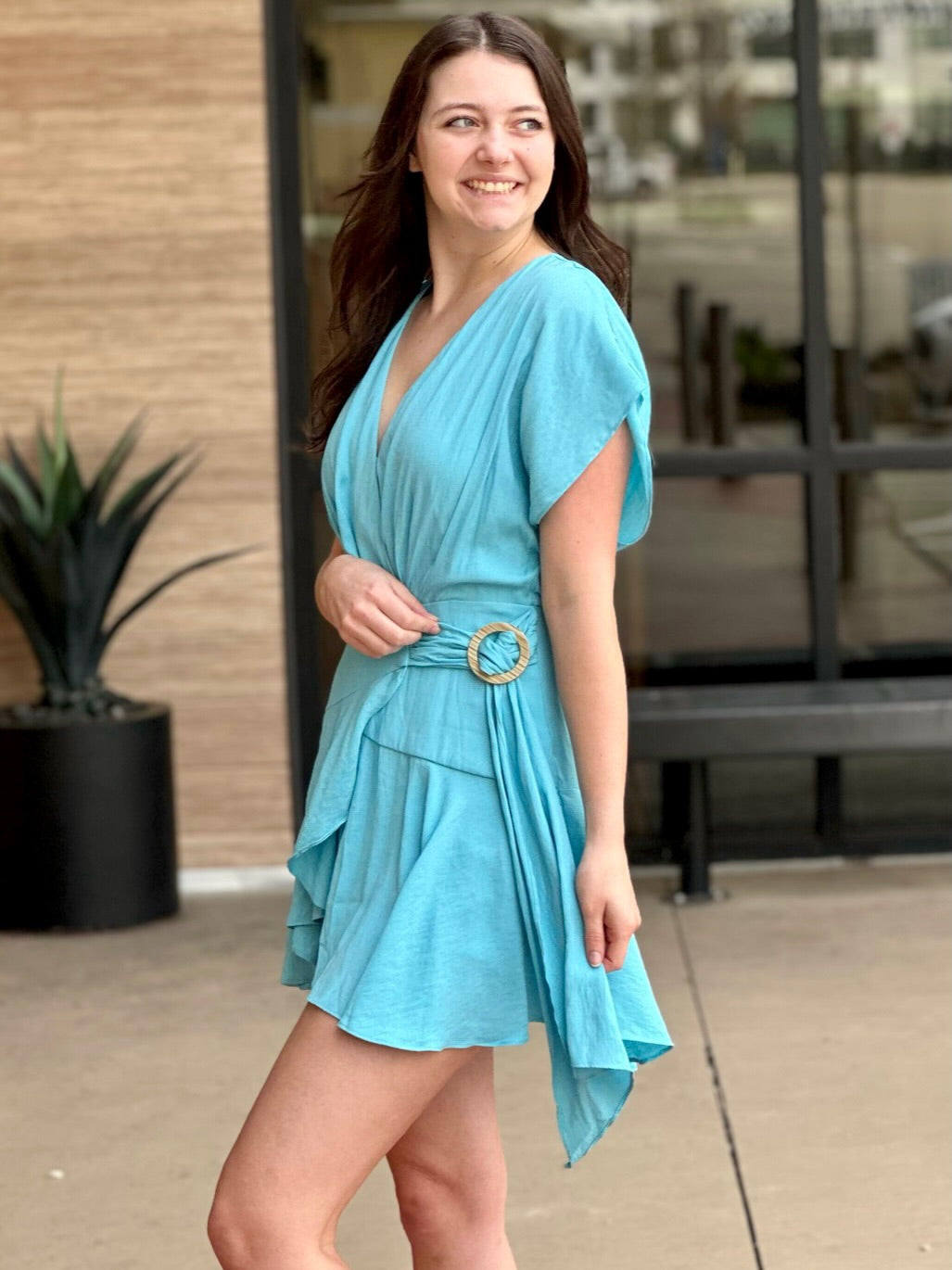 Megan in clear blue romper side view looking to the side smiling