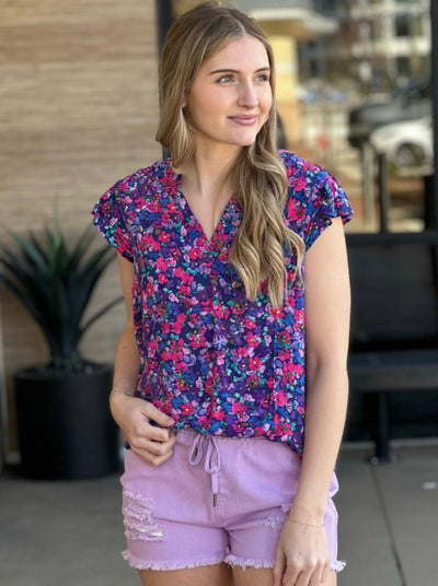 Lexi in multi blouse looking to the side