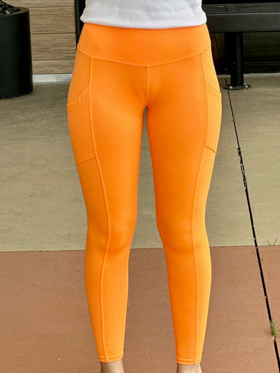 Megan in bright orange leggings front view