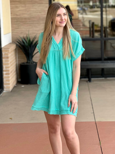 Lexi in mint dress front view looking to the side hand in pocket
