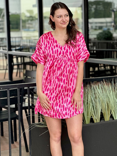 Megan in hot pink dress looking to the side soft smile