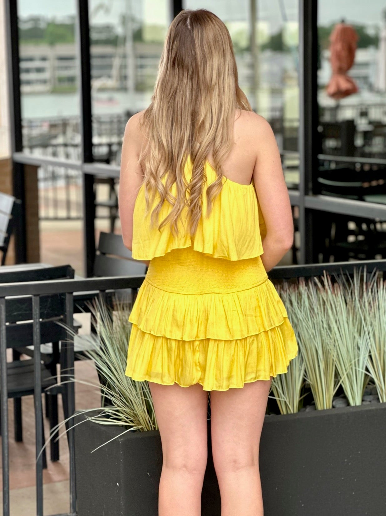 Lexi in yellow romper back view
