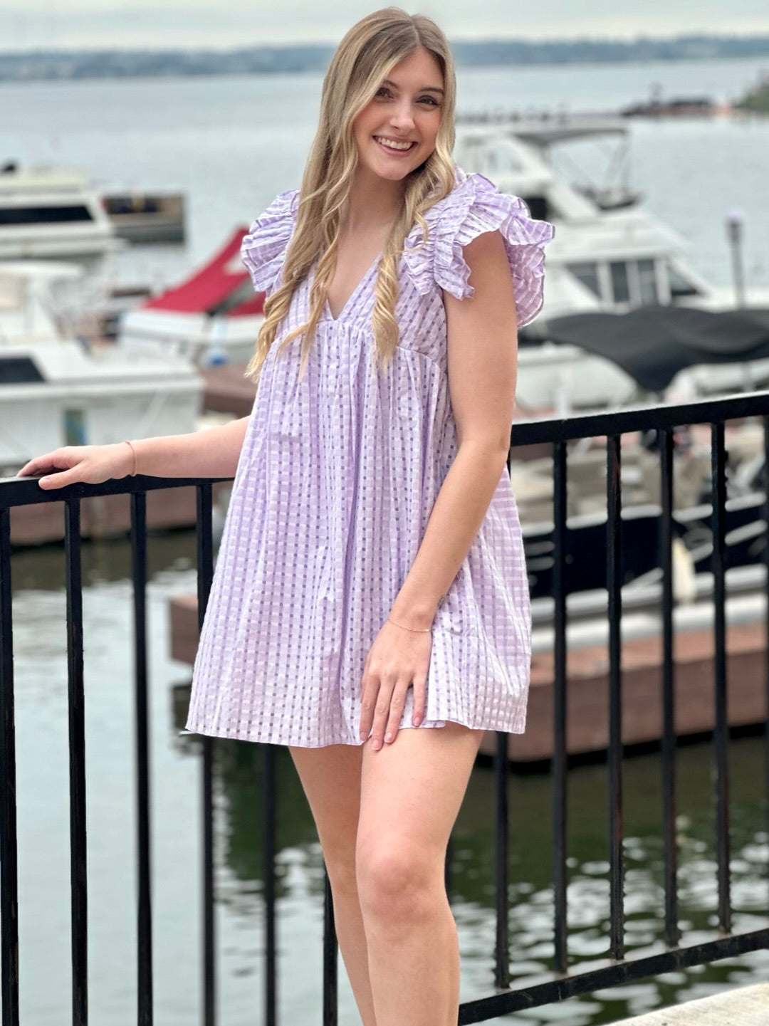 Lexie in lavender dress side view hand on leg
