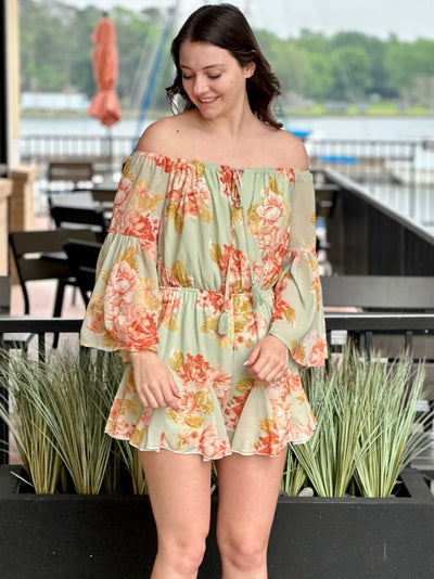 Megan in sage romper holding ties looking to the side