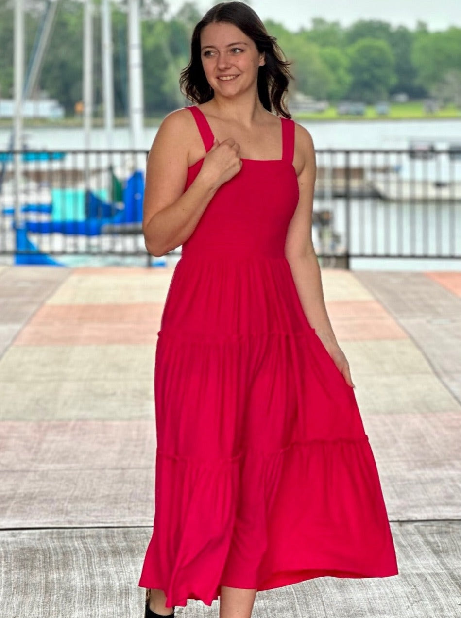 Megan in hot pink midi dress front view holding strap