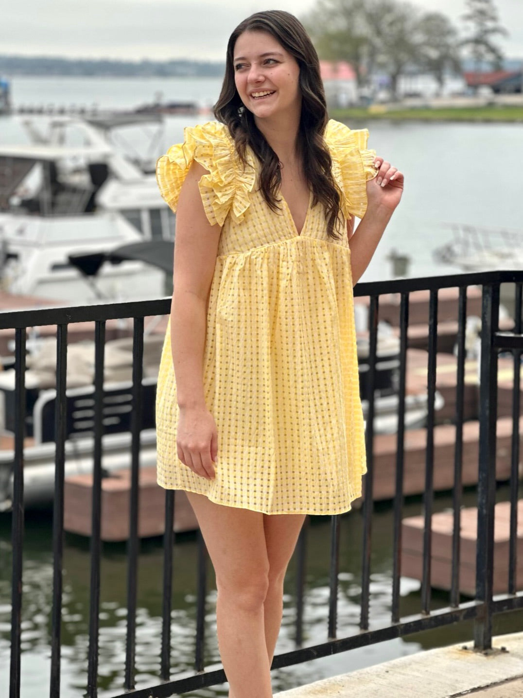 Megan in lemon dress looking to the side