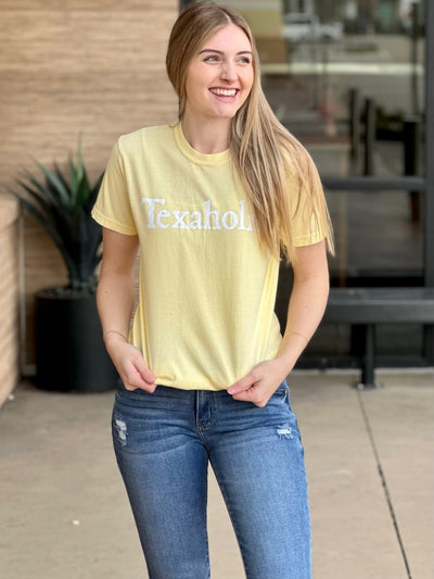 Lexi in banana short sleeve front view looking to the side holding tee