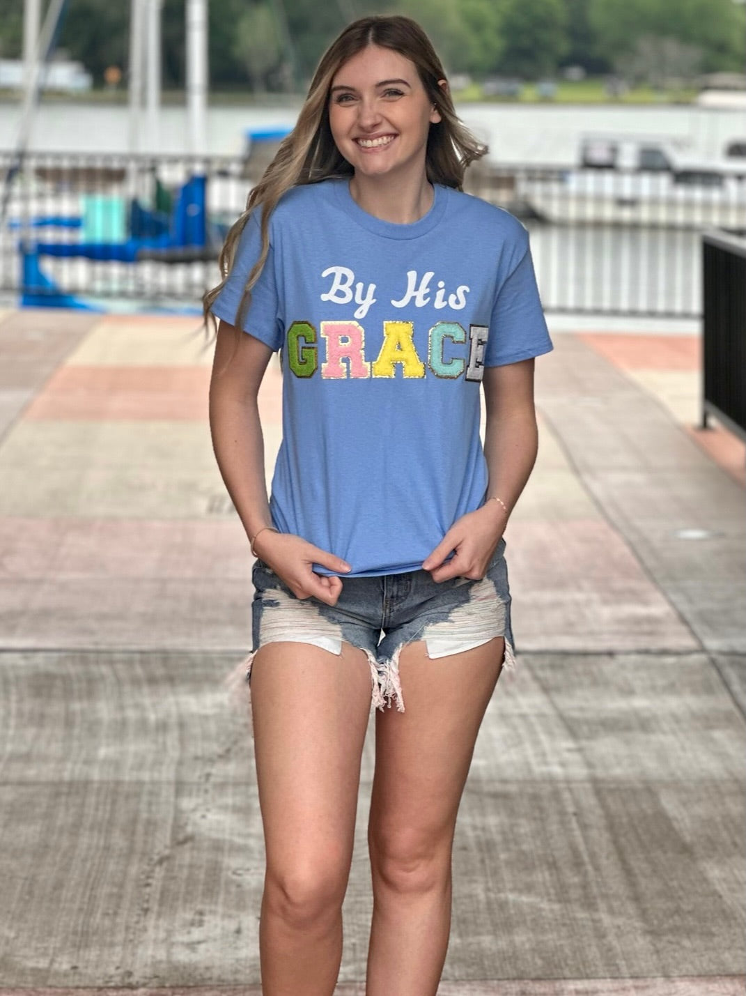 Lexi in carolina blue tee front view holding shirt